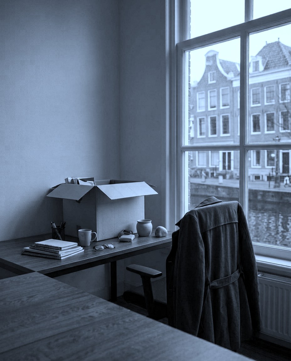 Jas over een lege stoel bij een raam